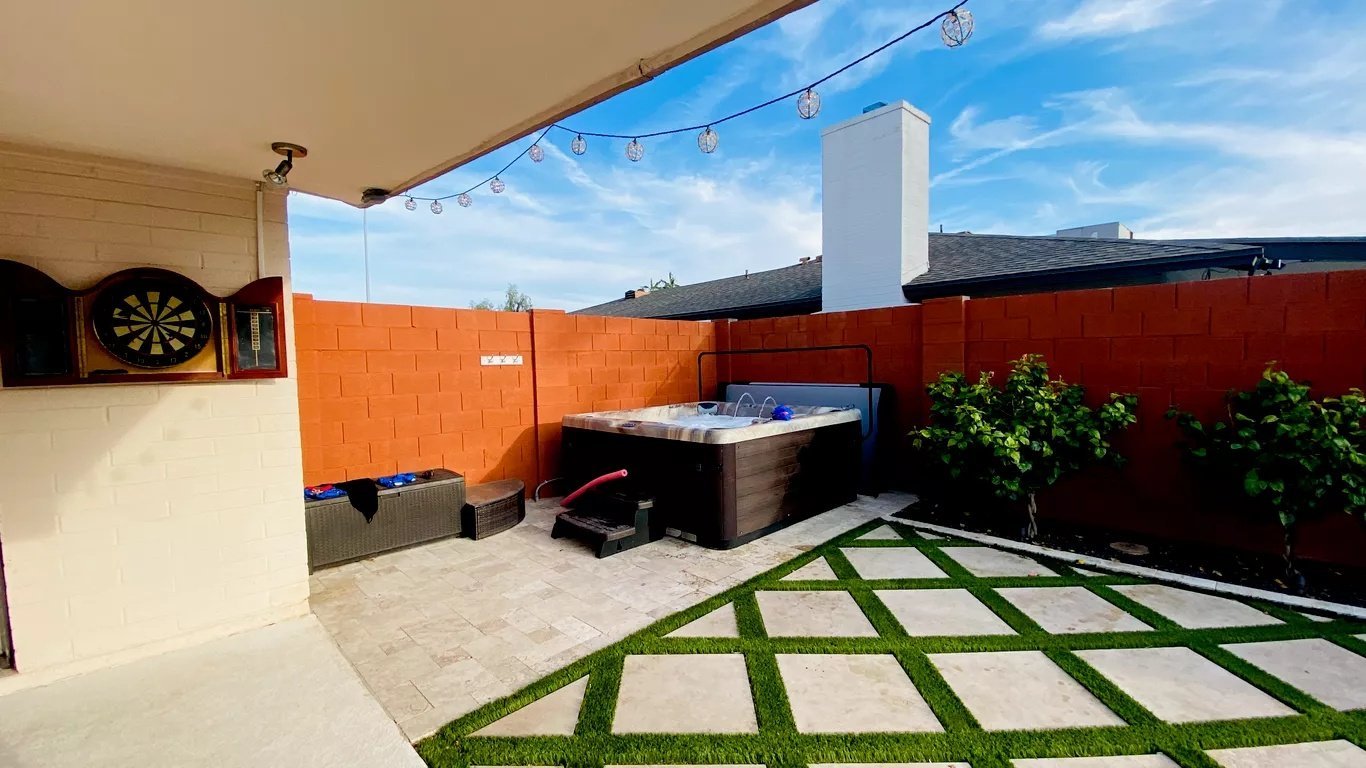 Backyard spa with paver and turf patio